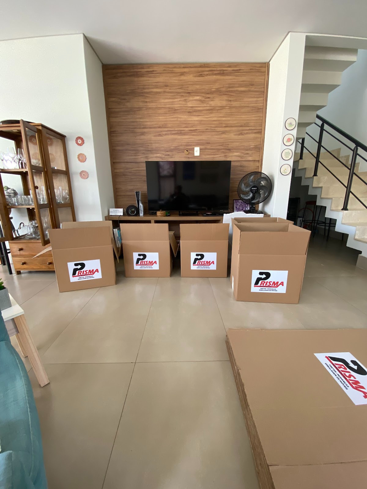 Caixas de papelão com a etiqueta da Prisma organizadas na sala de um cliente antes da mudança