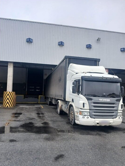 Carreta Scania branca na doca de descarga em Maracanaú