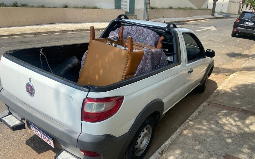 Picape carregada com sofá, móveis e caixas amarrados para um pequeno frete